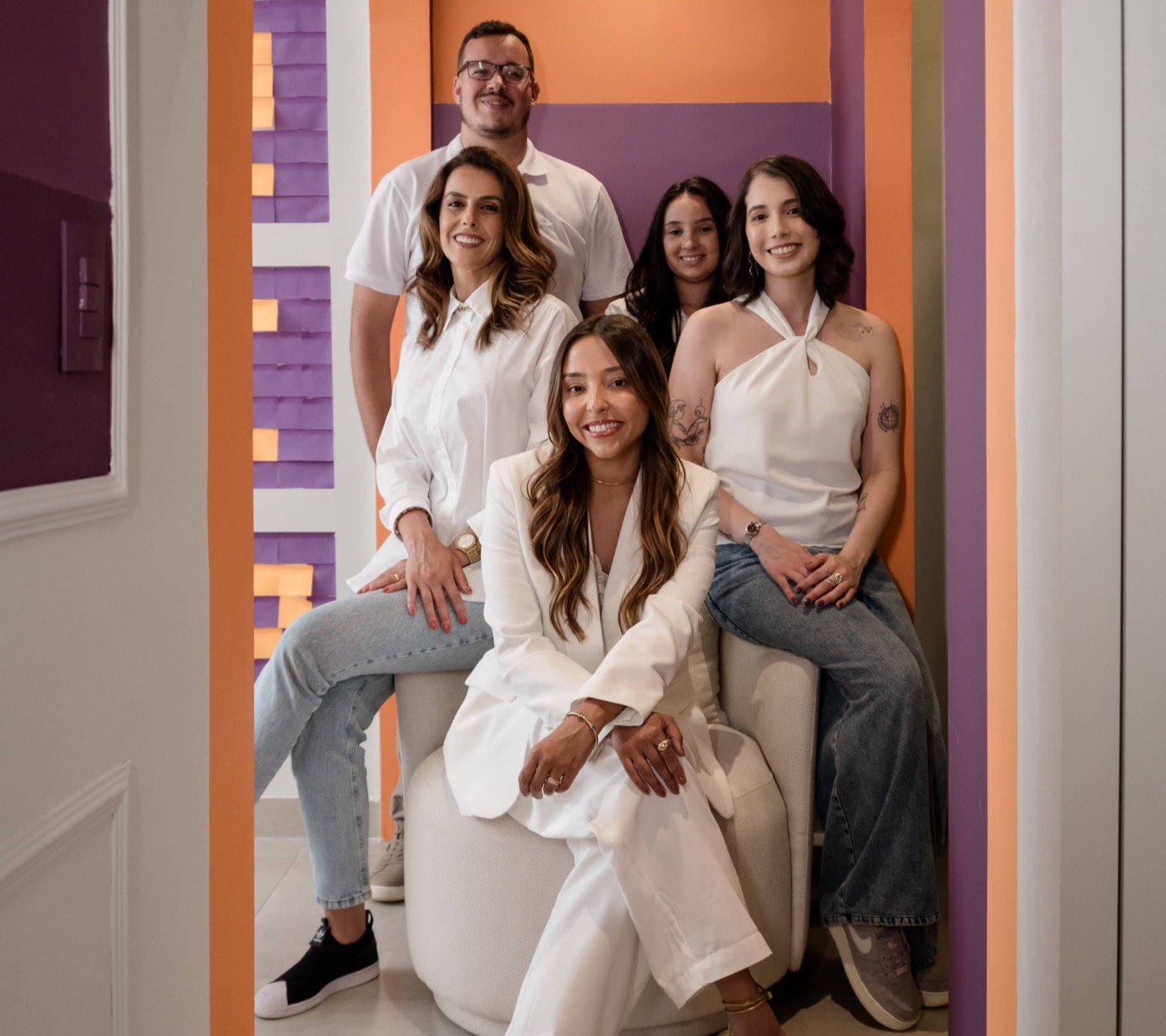 Time completo da Greap reunido sob o arco roxo e laranja do escritório